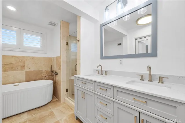 a bathroom with a tub a sink and mirror