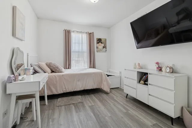 a bedroom with a bed a flat screen tv and dresser