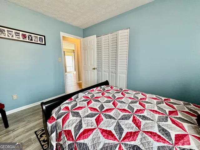 a bedroom with a bed and a painting on the wall