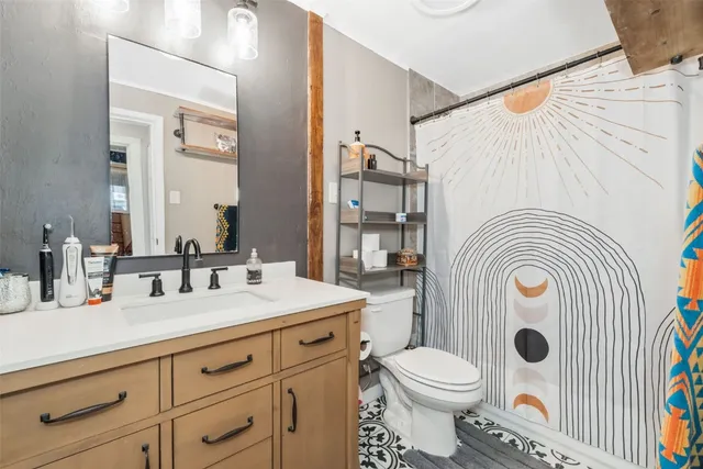 a bathroom with a sink a toilet mirror vanity and shower