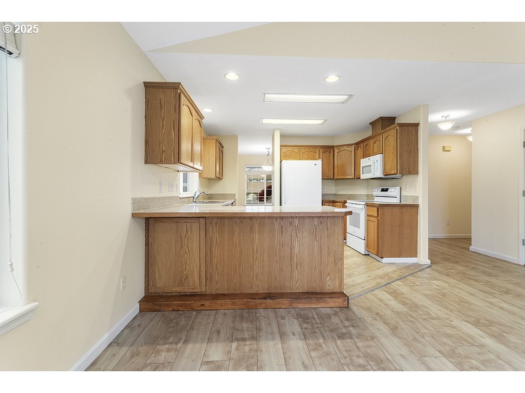 1575 Southeast Dexter Lane Gresham, OR 97080 - Photo 21 of 48 a kitchen with kitchen island granite countertop wooden floors and white stainless steel appliances