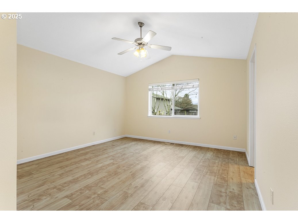 1575 Southeast Dexter Lane Gresham, OR 97080 - Photo 26 of 48 an empty room with wooden floor chandelier fan and windows