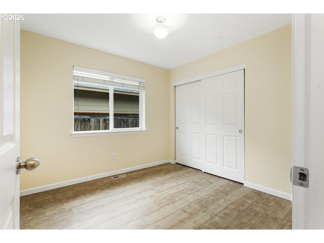 1575 Southeast Dexter Lane Gresham, OR 97080 - Photo 37 of 48 a view of an empty room with wooden floor and a window