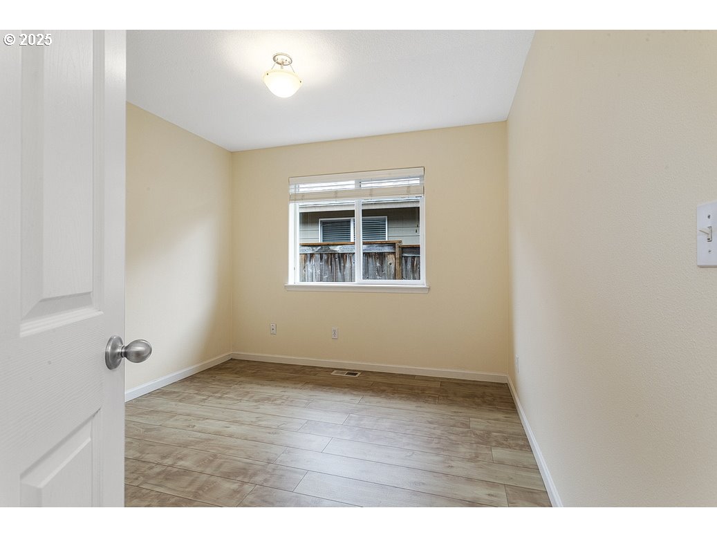 1575 Southeast Dexter Lane Gresham, OR 97080 - Photo 39 of 48 an empty room with wooden floor and windows