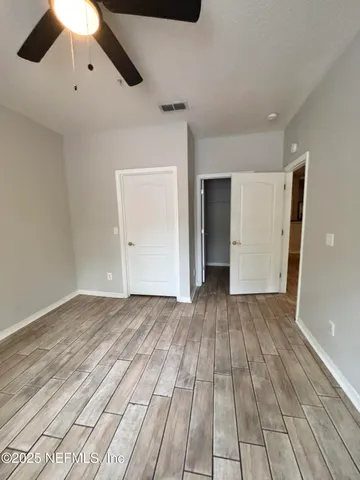 a view of an empty room with wooden floor