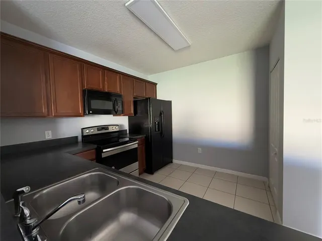 a kitchen with a refrigerator and a stove top oven