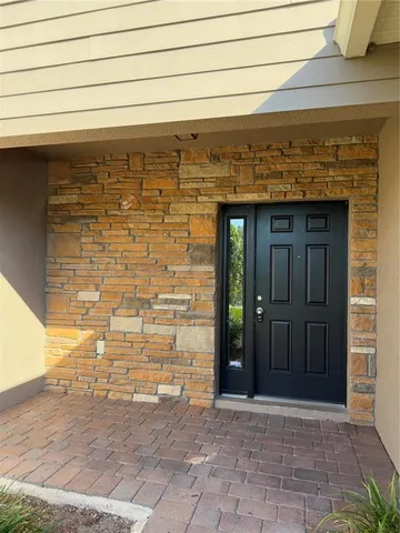 a view of a hallway to an empty room with stairs