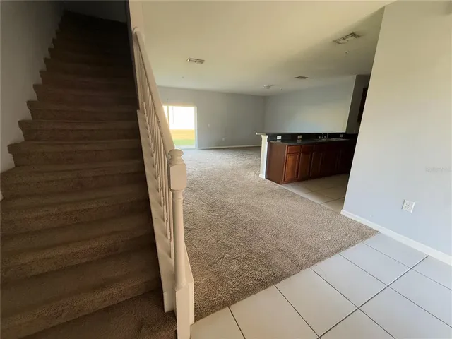 a view of a hallway with a dining table and chandelier