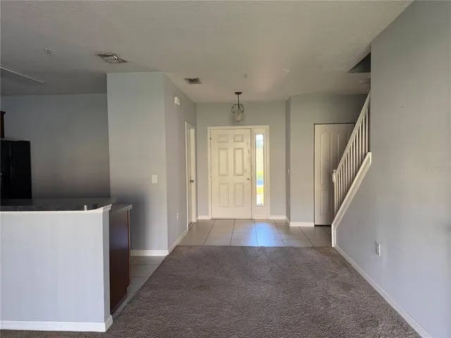 a kitchen with granite countertop a refrigerator and a stove top oven