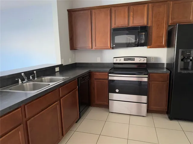 a kitchen with granite countertop stainless steel appliances and a refrigerator
