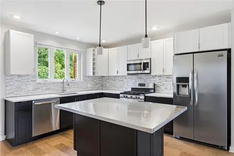 a kitchen with a sink a microwave a stove and refrigerator