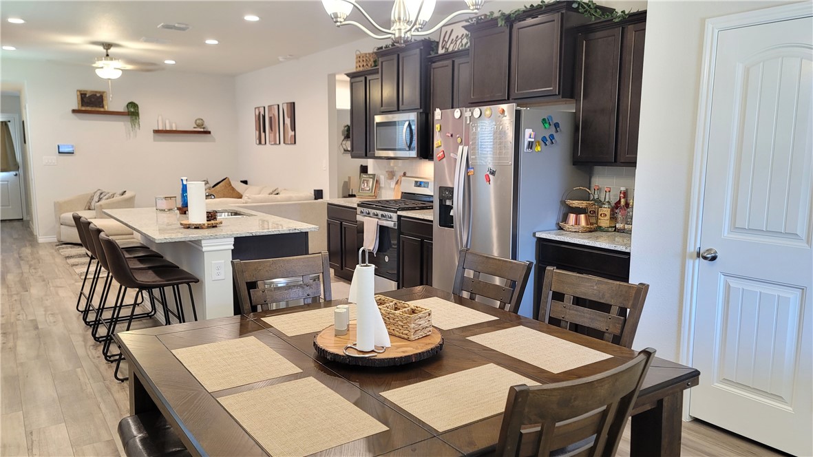 7633 Shadow Rider Lane Corpus Christi, TX 78414 - Photo 12 of 23 a kitchen with stainless steel appliances kitchen island granite countertop a dining table and chairs