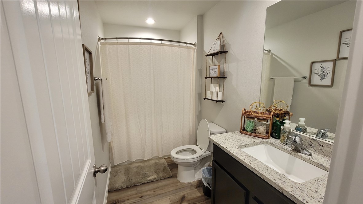 7633 Shadow Rider Lane Corpus Christi, TX 78414 - Photo 19 of 23 a bathroom with a granite countertop sink toilet a mirror and shower
