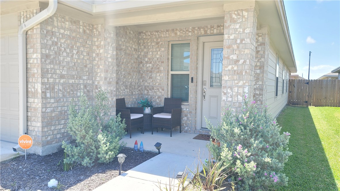 7633 Shadow Rider Lane Corpus Christi, TX 78414 - Photo 2 of 23 a view of a patio with table and chairs potted plants next to a large window