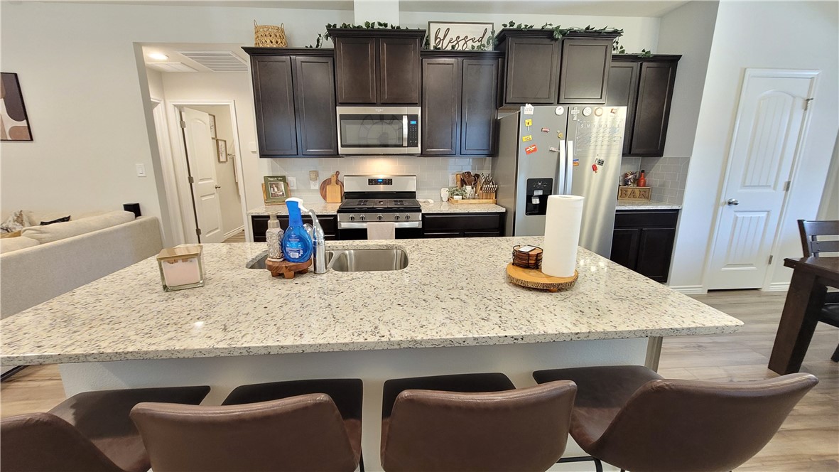7633 Shadow Rider Lane Corpus Christi, TX 78414 - Photo 9 of 23 a kitchen with a table chairs refrigerator and microwave