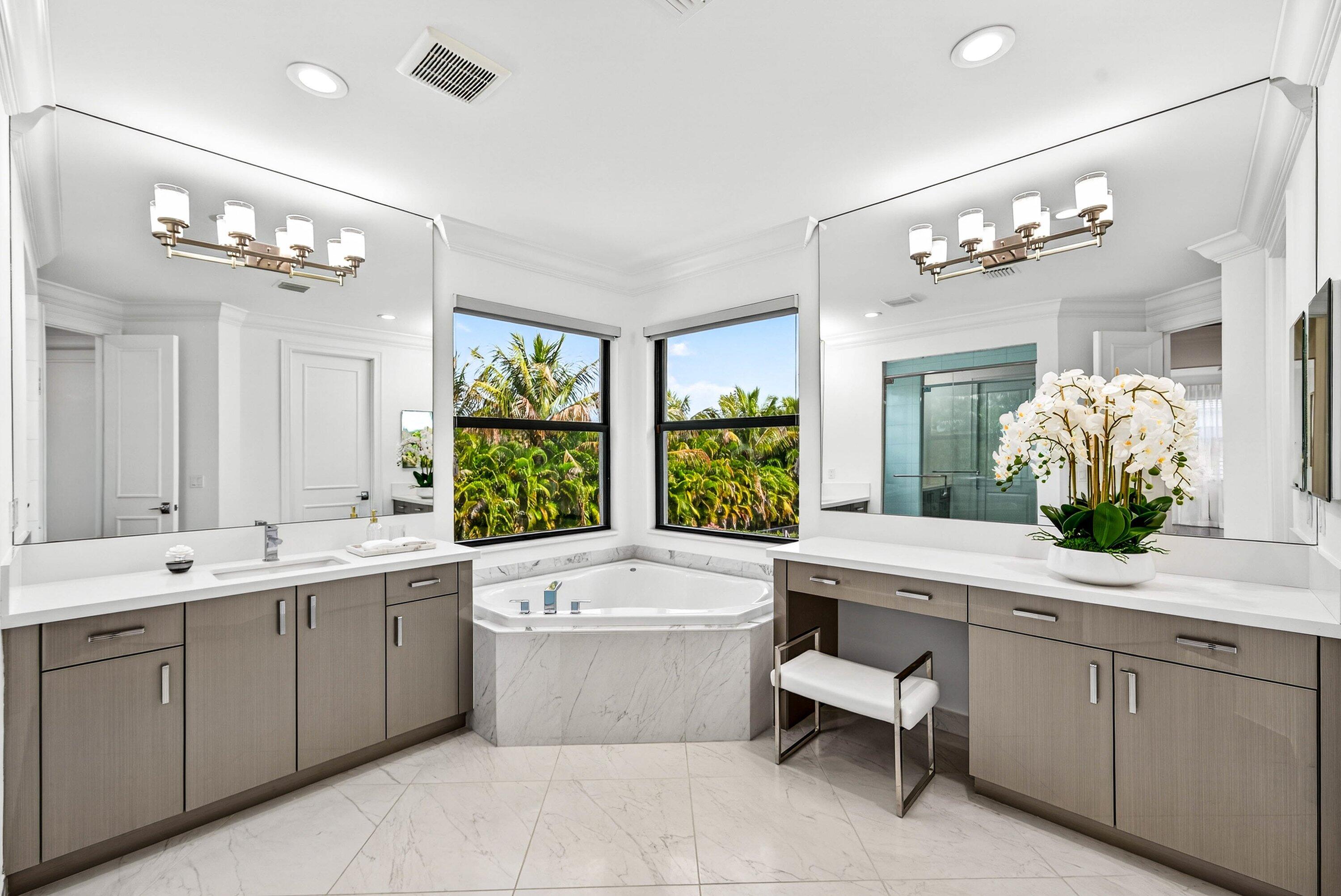 9065 Benedetta Place Boca Raton, FL 33496 - Photo 19 of 51 a bathroom with a tub a double vanity sink a large mirror and a bathtub
