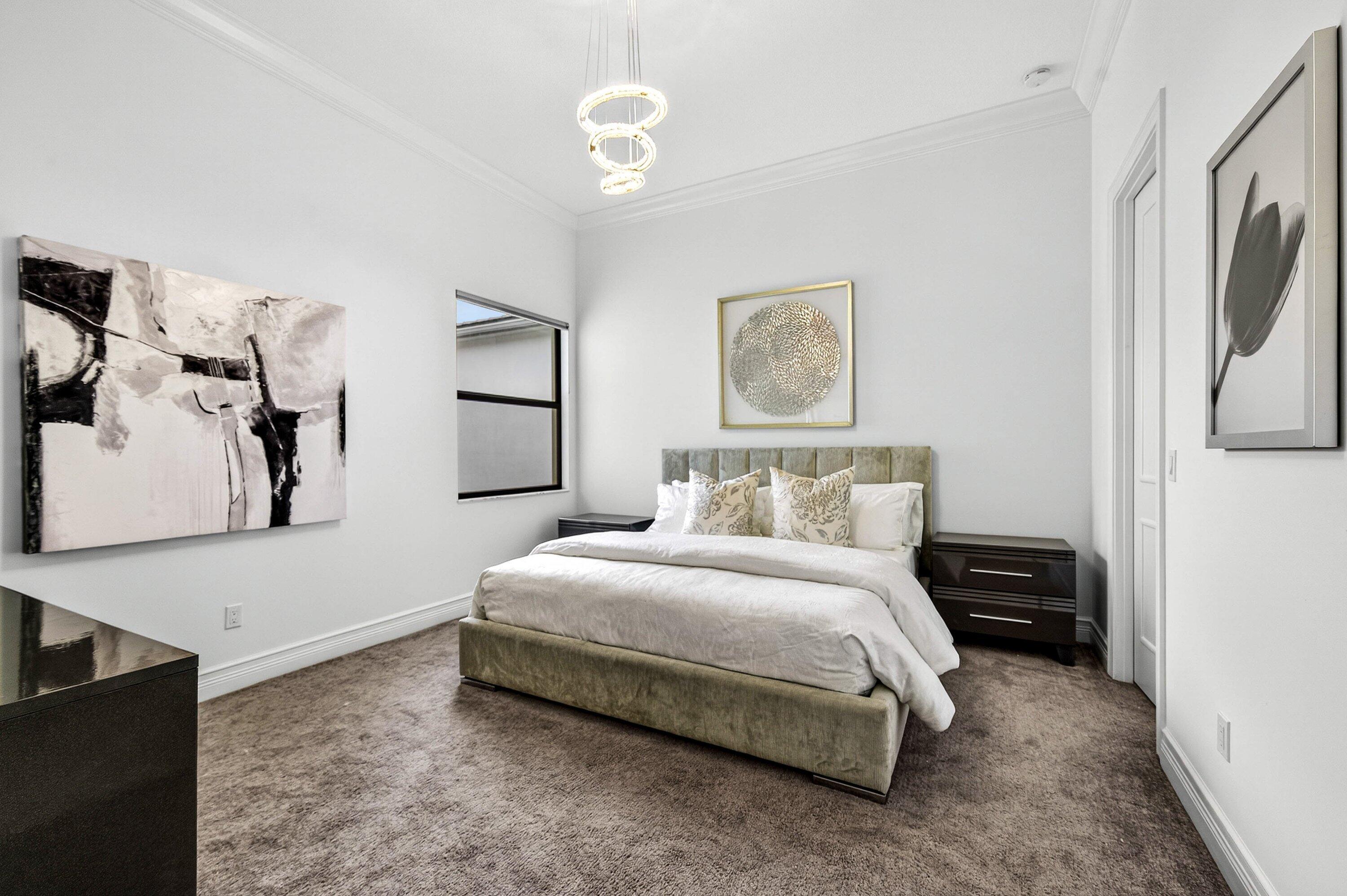 9065 Benedetta Place Boca Raton, FL 33496 - Photo 28 of 51 a bedroom with a bed and a chandelier