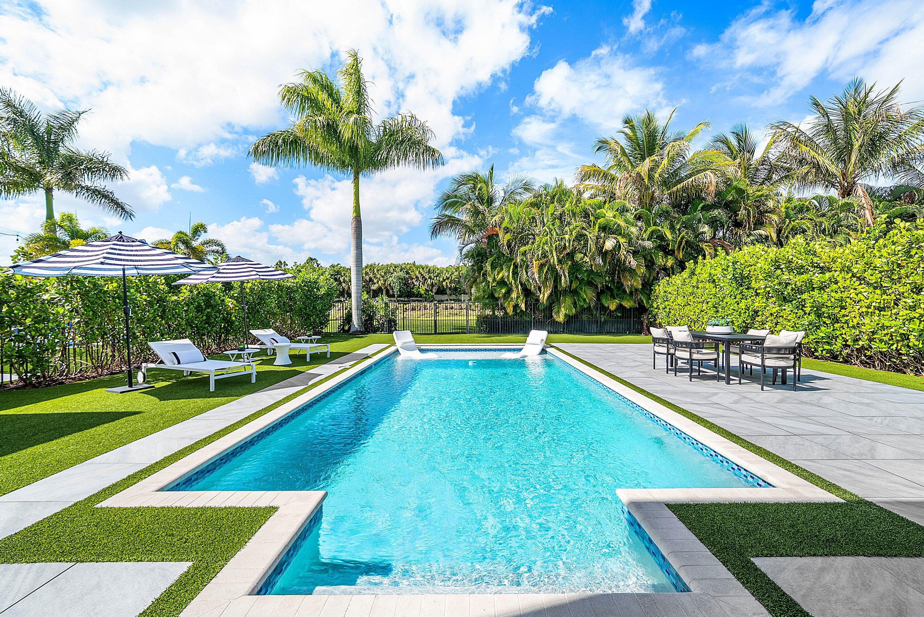 9065 Benedetta Place Boca Raton, FL 33496 - Photo 35 of 52 a view of a swimming pool with a lounge chairs