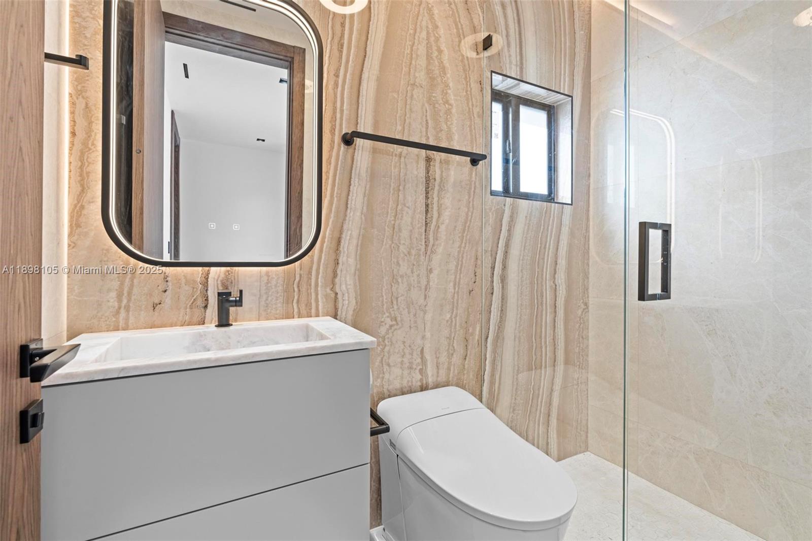 7755 Southwest 85th Court Miami, FL 33143 - Photo 43 of 70 a bathroom with a toilet a sink and mirror