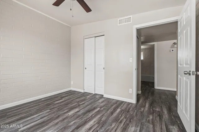 a view of a room with wooden floor and a ceiling fan