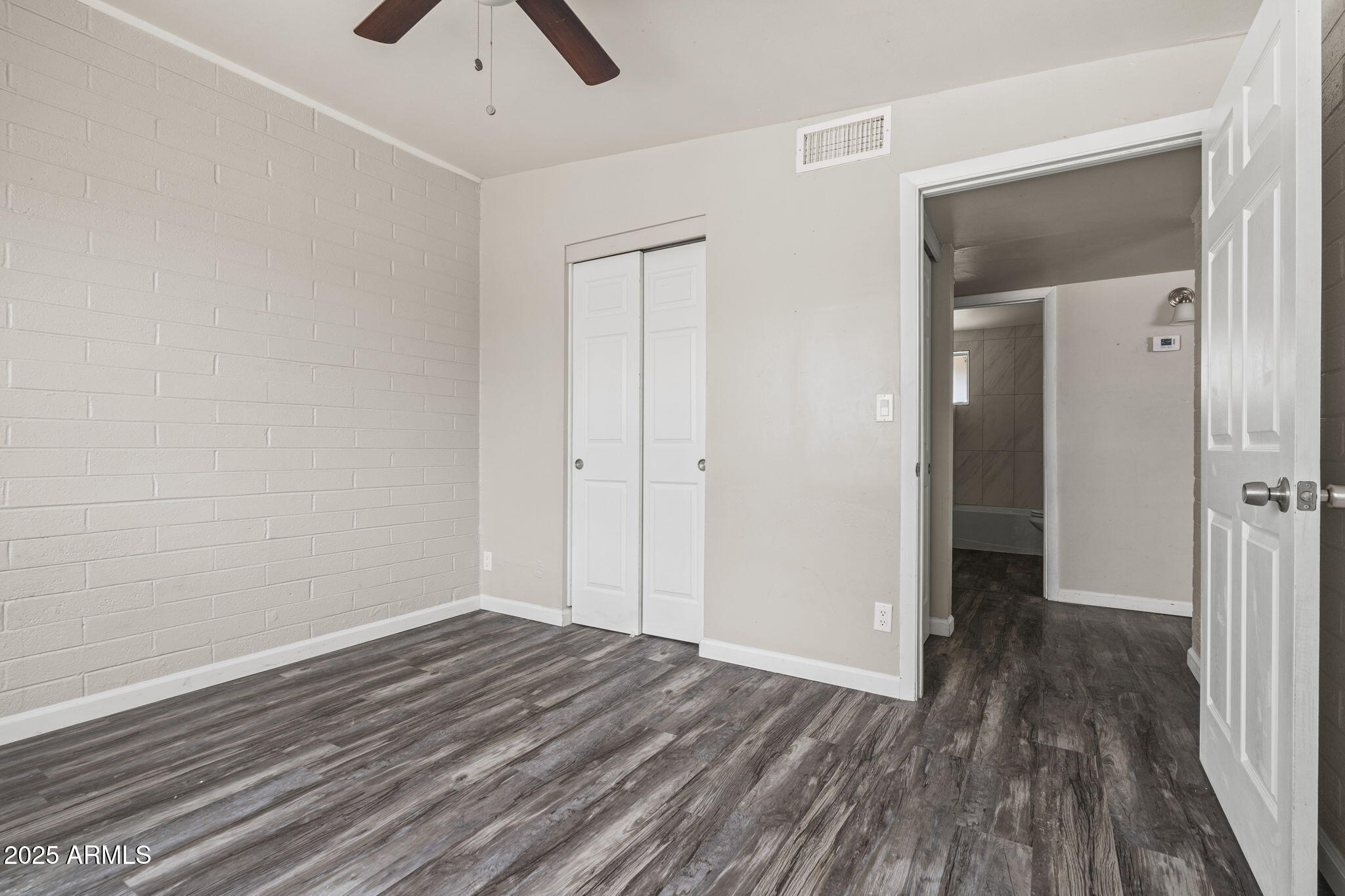 221 5th Avenue East, Unit 225 Buckeye, AZ 85326 - Photo 11 of 14 a view of a room with wooden floor and a ceiling fan