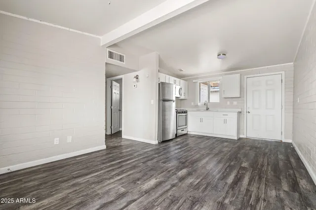 a view of a kitchen with wooden floor and electronic appliances