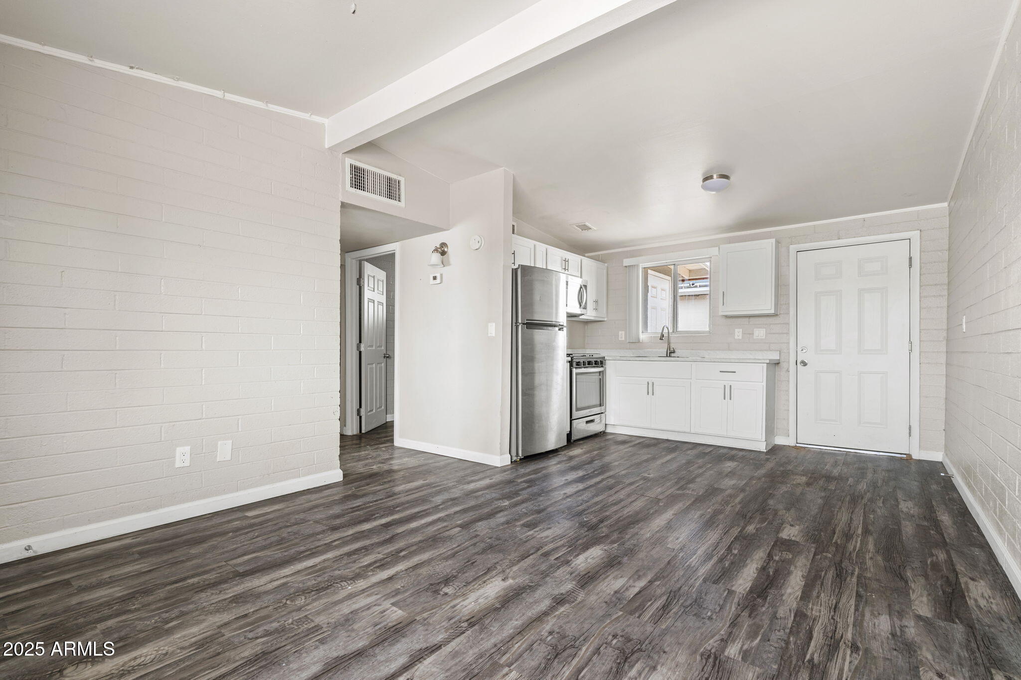 221 5th Avenue East, Unit 225 Buckeye, AZ 85326 - Photo 2 of 14 a view of a kitchen with wooden floor and electronic appliances
