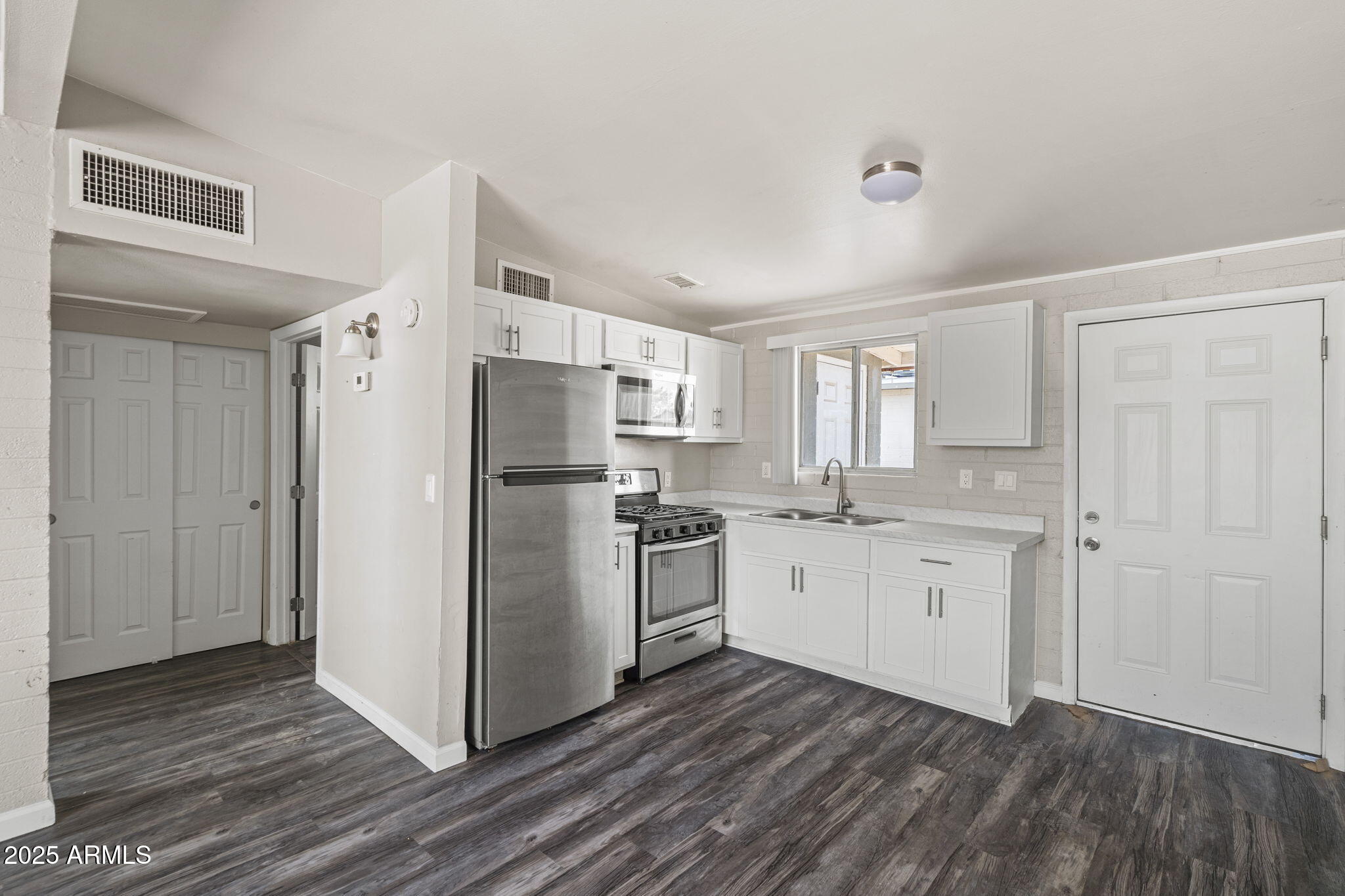 221 5th Avenue East, Unit 225 Buckeye, AZ 85326 - Photo 7 of 14 a kitchen with stainless steel appliances a refrigerator sink and cabinets