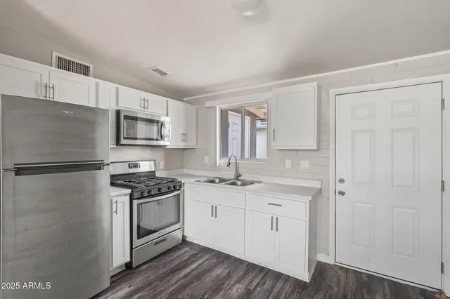 a kitchen with white cabinets and white appliances