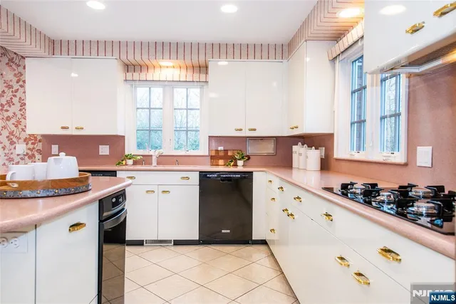 a kitchen with granite countertop a sink stove and cabinets