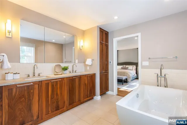 a bathroom with a tub sink and mirror