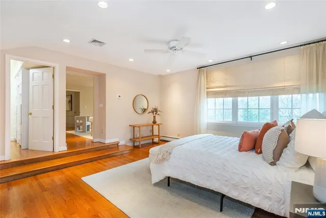 a bedroom with a bed and a large window with the outer view