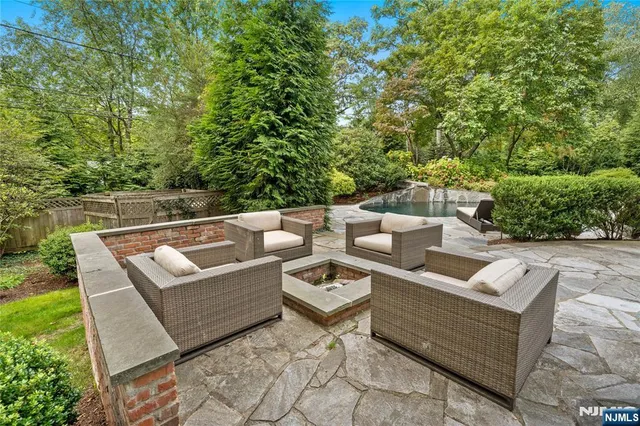 an aerial view of a house with outdoor space and trees all around