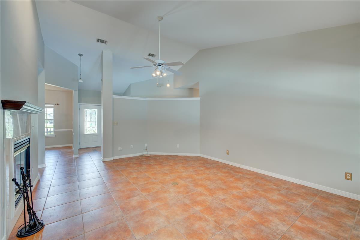 1818 Huntington Road Niceville, FL 32578 - Photo 11 of 53 an empty room with a fireplace and chandelier fan