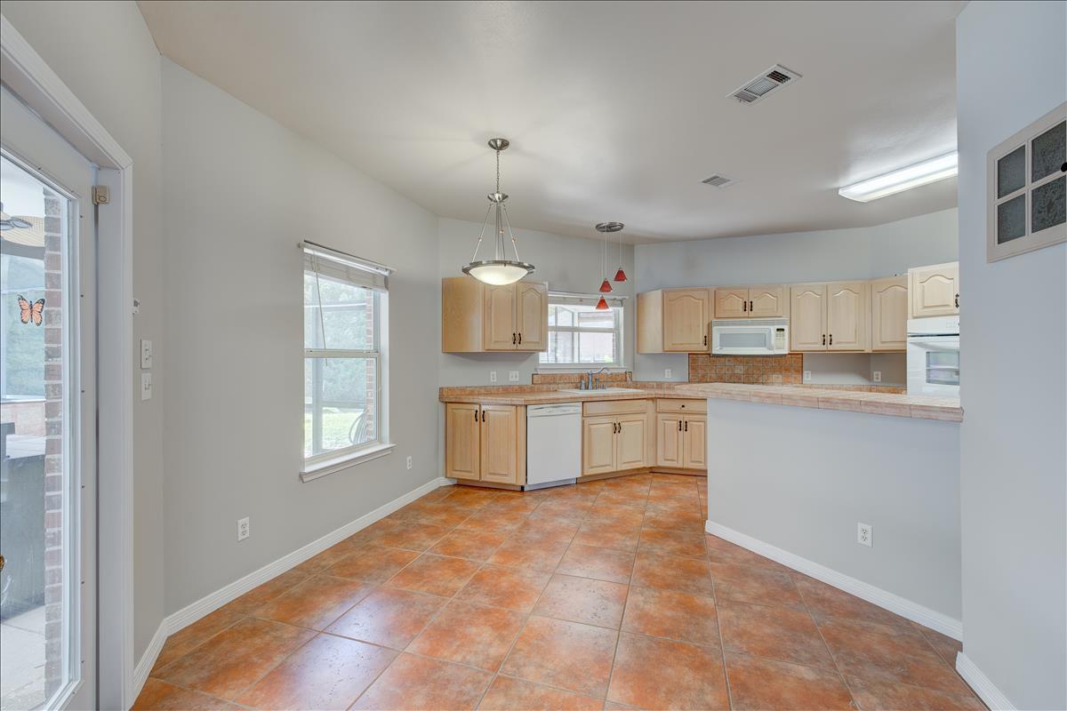 1818 Huntington Road Niceville, FL 32578 - Photo 12 of 53 a large white kitchen with granite countertop a stove a sink a window and dining table