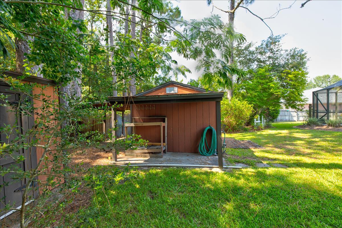 1818 Huntington Road Niceville, FL 32578 - Photo 46 of 53 a backyard of a house with table and chairs under an umbrella