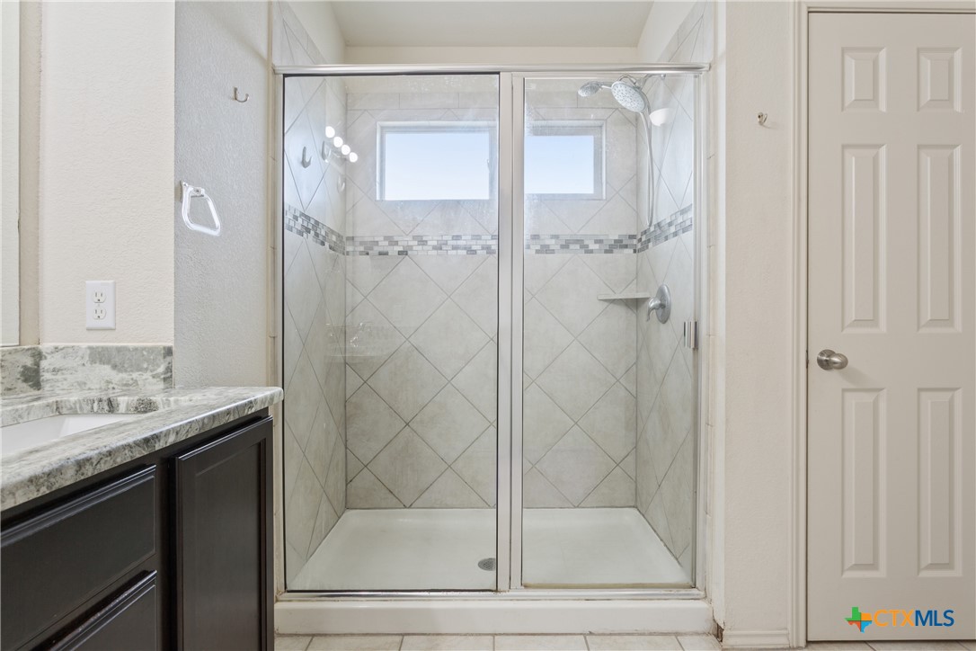 231 Druse Lane Jarrell, TX 76537 - Photo 18 of 38 a bathroom with a granite countertop mirror and a sink