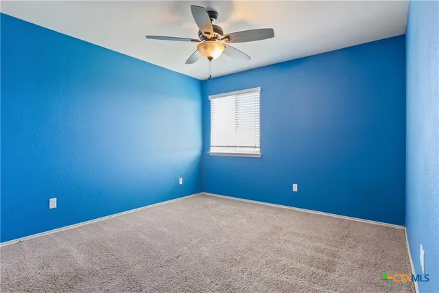 an empty room and chandelier fan