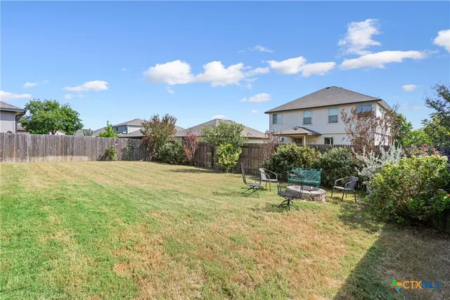 a backyard of a house with table and chairs