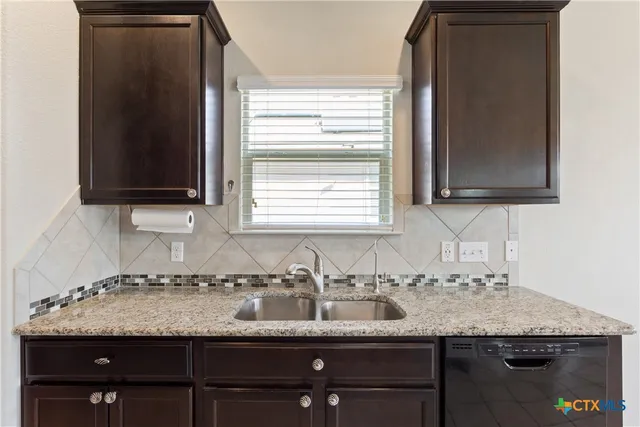 a sink sitting next to a granite countertop sink