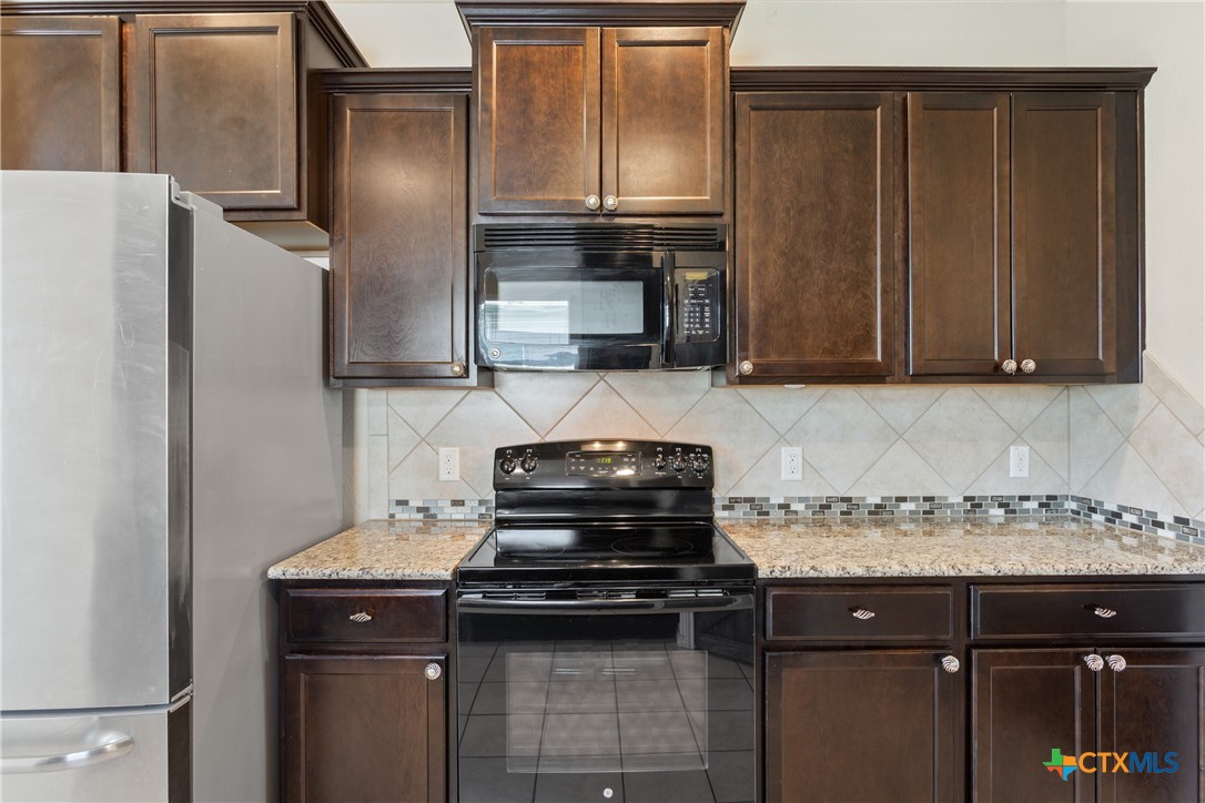 231 Druse Lane Jarrell, TX 76537 - Photo 7 of 38 a kitchen with a refrigerator and a stove