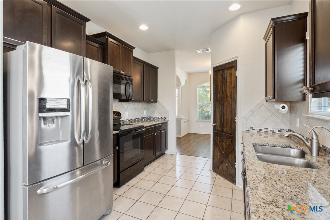 231 Druse Lane Jarrell, TX 76537 - Photo 10 of 38 a kitchen with stainless steel appliances granite countertop a refrigerator and a sink