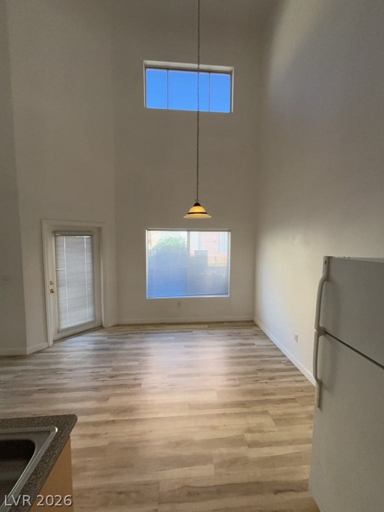 4915 East Russell Road, Unit 143 Las Vegas, NV 89120 - Photo 3 of 10 Natural light floods this room through high transom windows, highlighting the durable vinyl plank flooring.