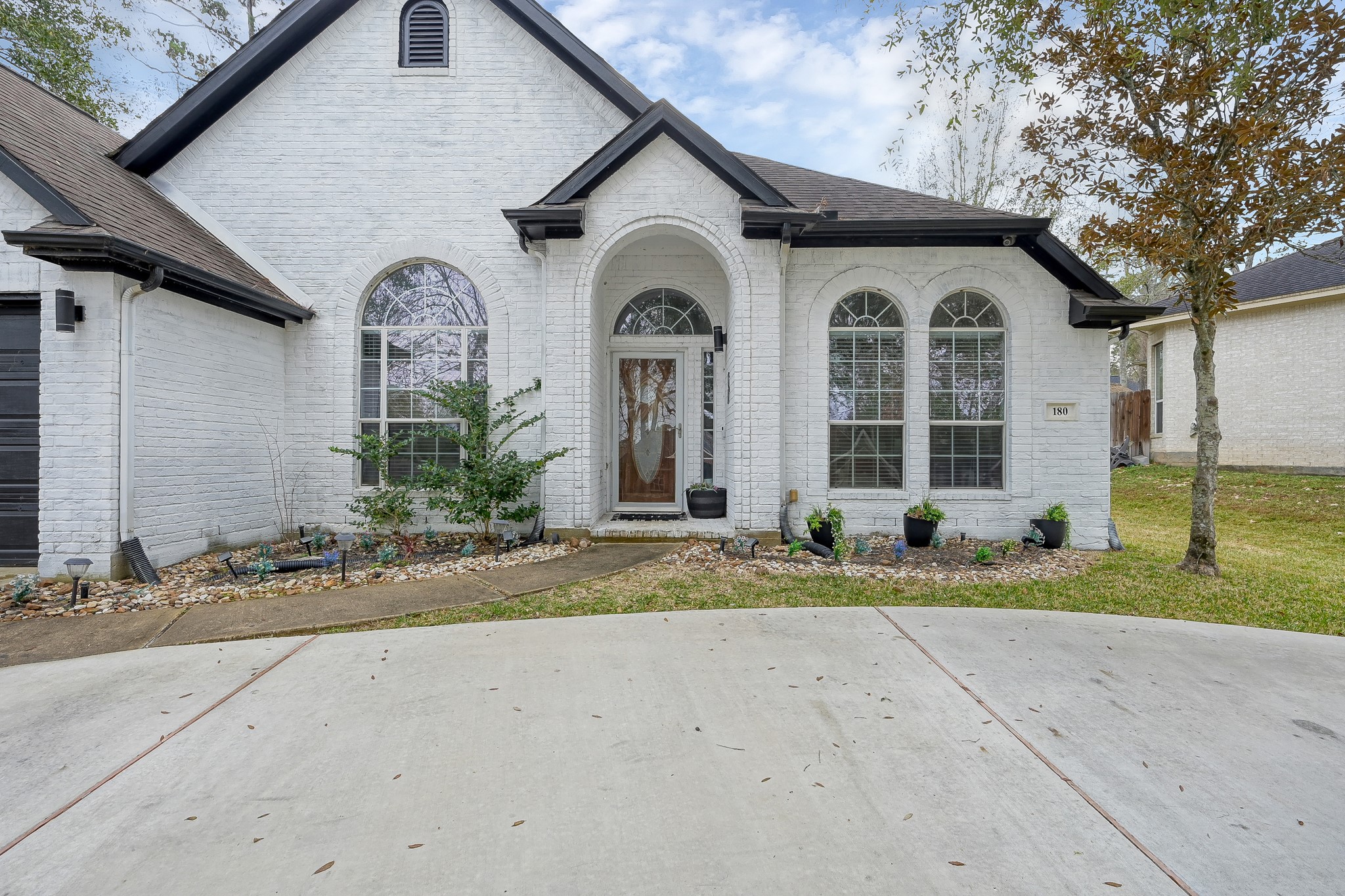180 Park Way Conroe, TX 77356 - Photo 3 of 23 a view of a white house with large windows and a small yard