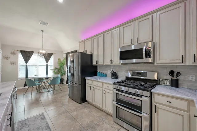 a kitchen with a refrigerator a microwave a stove and cabinets