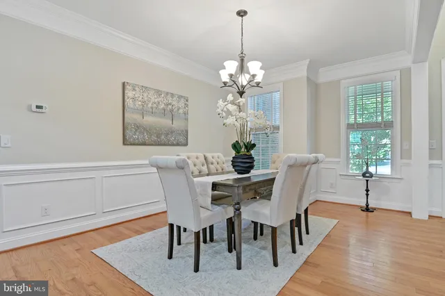 a kitchen with stainless steel appliances granite countertop a sink dishwasher and a refrigerator with wooden floor