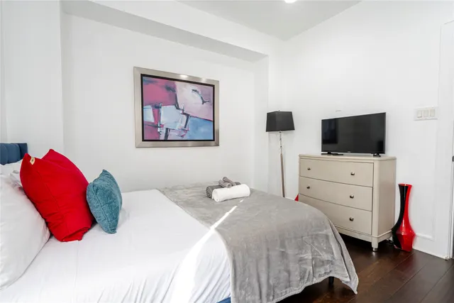 a bedroom with a bed and a flat screen tv