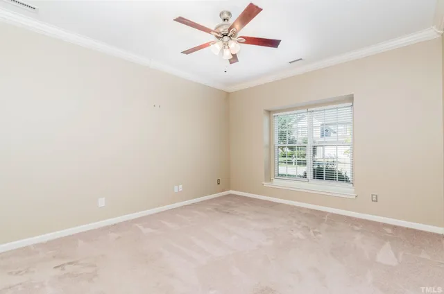 an empty room with windows and ceiling fan