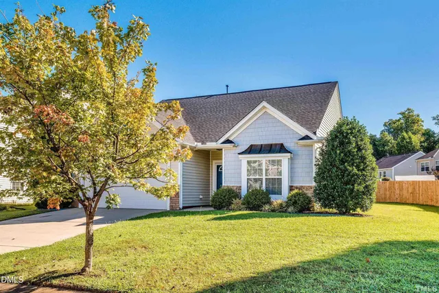a view of a house with backyard and tree