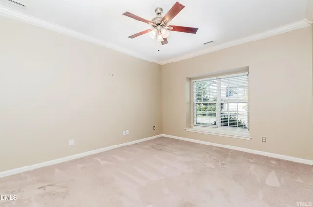 an empty room with windows and ceiling fan